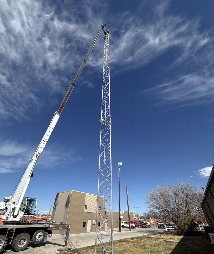 Crane lifting equipment to the top of a lattice communications tower