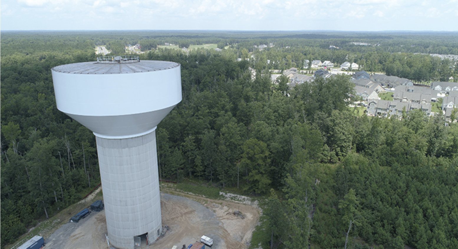 Elevated water tank above a forested neighborhood